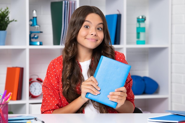 Zurück zur Schule Teenager-Schulmädchen mit lernbereitem Buch Glückliches Mädchen steht positiven und lächelnden Emotionen gegenüber