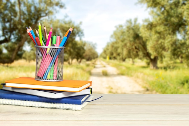 Zurück zur Schulkonzepttafel mit Bleistiftbox und Büchern, Notizbuch und Uhr auf Holztisch