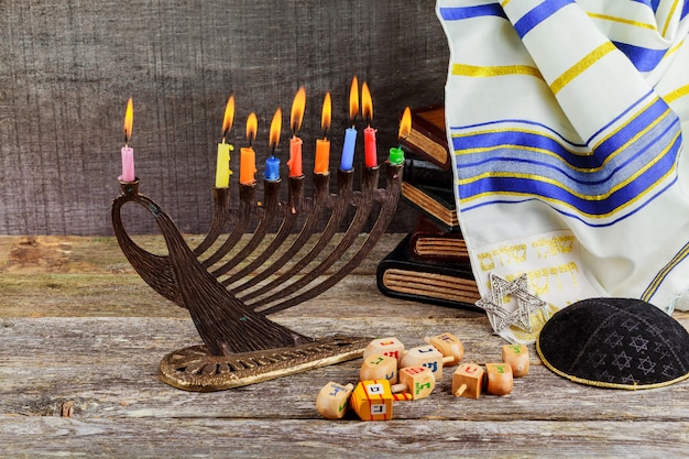 Zurückhaltendes Bild jüdischen Feiertags Chanukka-Hintergrundes mit menorah traditionellen Kandelabern und brennenden Kerzen