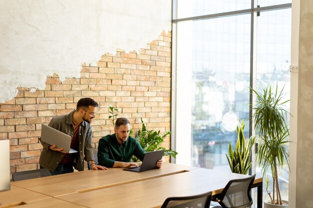 Zusammenarbeit in Bewegung Fachleute arbeiten zusammen in einem modernen Büro mit Ziegelsteinmauern