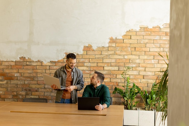 Zusammenarbeit in Bewegung Fachleute arbeiten zusammen in einem modernen Büro mit Ziegelsteinmauern