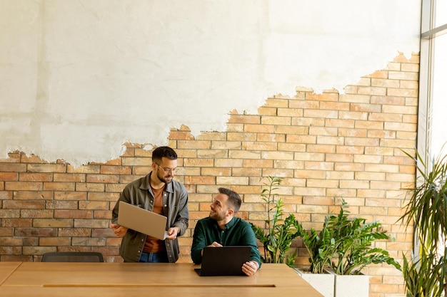 Zusammenarbeit in Bewegung Fachleute arbeiten zusammen in einem modernen Büro mit Ziegelsteinmauern