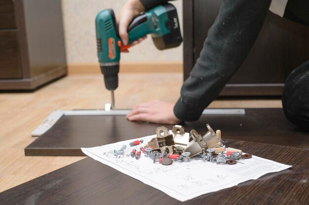 Zusammenbau von Möbeln aus Spanplatten mit einem Akkuschrauber aus nächster Nähe