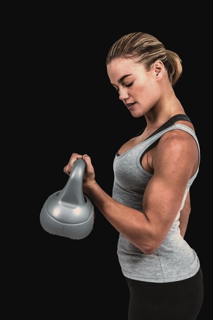 Zusammengesetztes Bild der schweren muskulösen Frau, die Kettlebell anhebt?