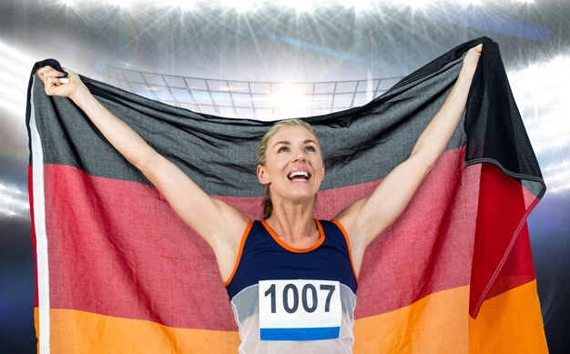 Zusammengesetztes Bild des Athleten, der nach dem Sieg mit deutscher Flagge posiert