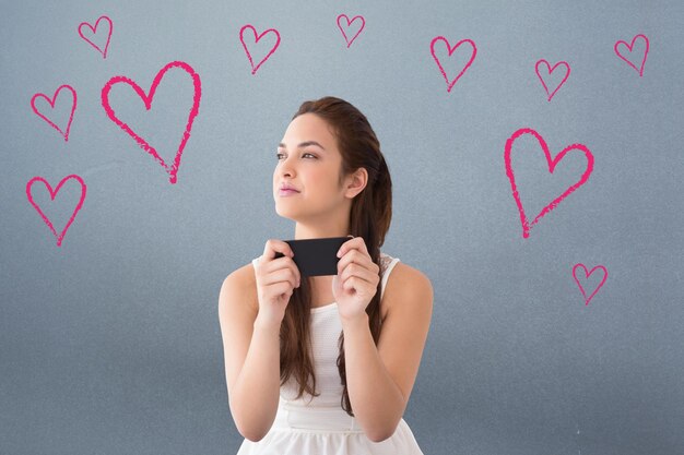 Zusammengesetztes Bild des durchdachten Brunette, der ihr Telefon hält