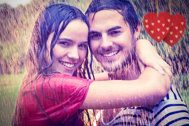 Zusammengesetztes Bild des netten Paares, das unter dem Regen umarmt
