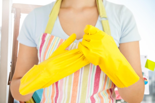 Zusammengesetztes Bild einer Frau, die ihre Gummihandschuhe auszieht