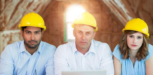 Zusammengesetztes Bild eines Porträts von Architekten, die Schutzhelme tragen, während sie am Tisch sitzen