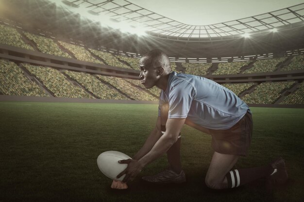 Zusammengesetztes Bild eines selbstbewussten Rugbyspielers, der wegschaut, während er den Ball mit 3D auf dem Kick-Tee hält
