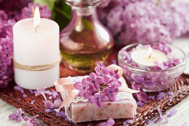 Zusammensetzung der Spa-Behandlung mit natürlichem Meersalz, aromatischem Öl und lila Blüten auf weißem Holz