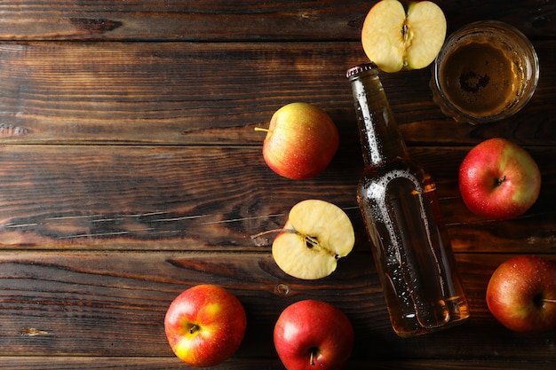 Zusammensetzung mit apfelwein und äpfeln auf holztisch