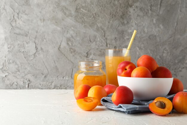 Zusammensetzung mit Aprikosen, Saft und Marmelade auf weißem Tisch