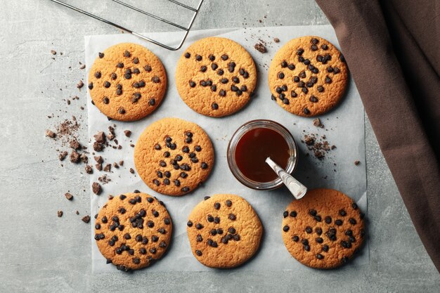 Zusammensetzung mit Chip Cookies und Karamell auf grauem Tisch