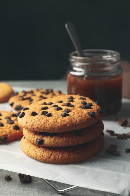 Zusammensetzung mit Chip Cookies und Karamell auf grauem Tisch