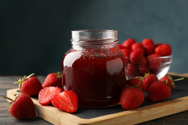 Zusammensetzung mit Erdbeermarmelade auf Holztisch, Nahaufnahme