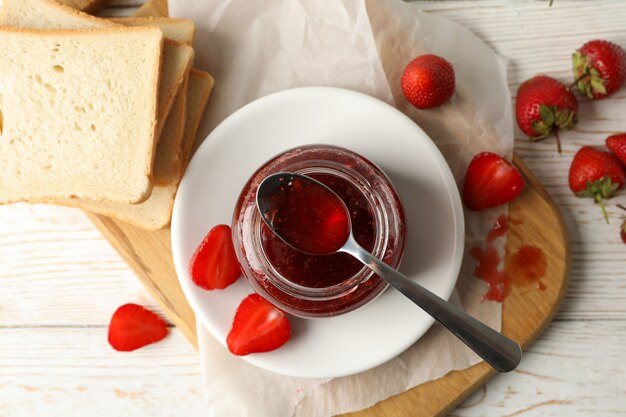 Zusammensetzung mit Erdbeermarmelade auf weißem Holz, Draufsicht