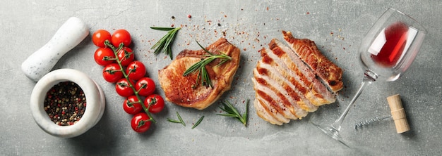 Zusammensetzung mit gebratenen Steaks, Wein und Gemüse. Gegrilltes Essen