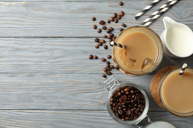 Zusammensetzung mit Gläsern des Eiskaffees auf hölzernem Hintergrund