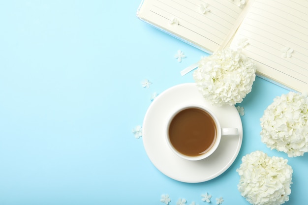 Zusammensetzung mit Hortensienblumen und Kaffee auf blauem Raum