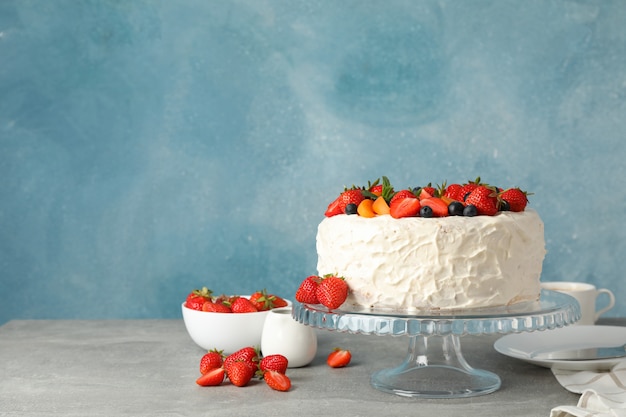 Zusammensetzung mit köstlichem Beerencremekuchen auf grauem Tisch