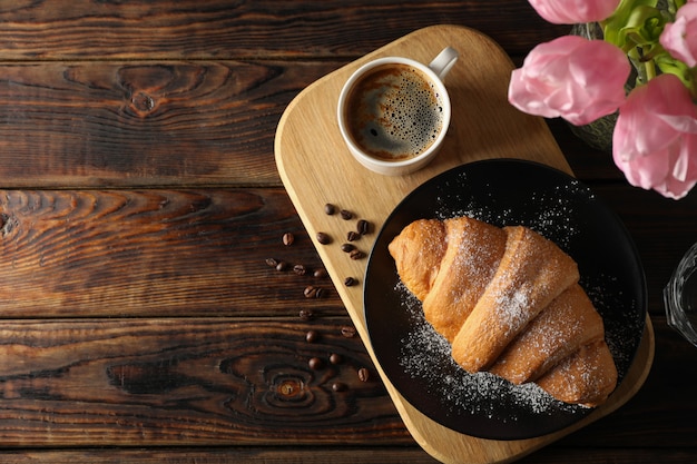 Zusammensetzung mit leckerem Croissant auf hölzernem Hintergrund, Draufsicht