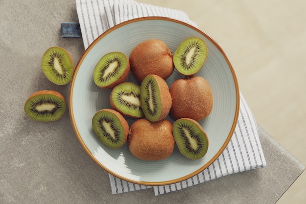 Zusammensetzung mit Platte der reifen Kiwi auf grauem Tisch