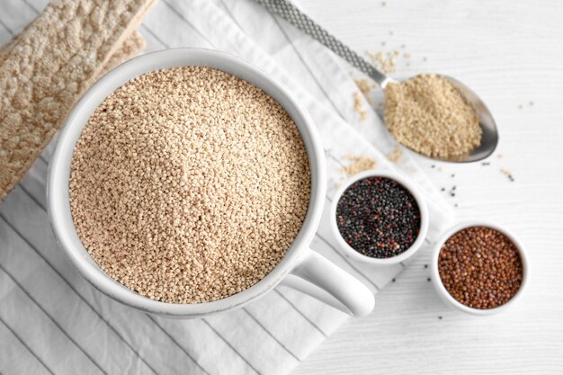 Zusammensetzung mit Quinoa-Samen in Tasse auf dem Tisch