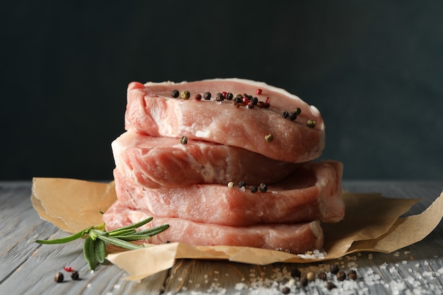 Zusammensetzung mit rohem Fleisch für Steak und Gewürze auf hölzernem Hintergrund