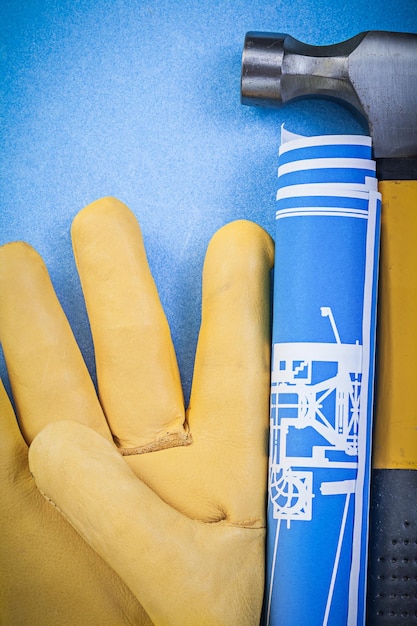 Zusammensetzung von Blaupausen für Klauenhammer-Schutzhandschuhe auf blauem Hintergrund