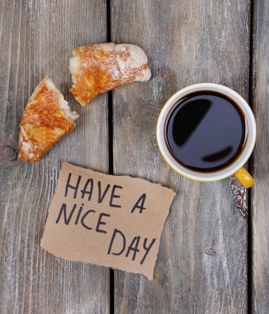 Foto zusammensetzung von frischem kaffee-croissant und papierkarten auf holzgrund