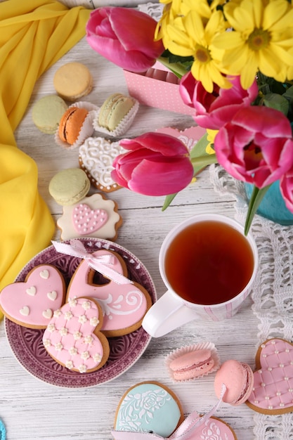 Foto zusammensetzung von frühlingsblumentee und -plätzchen auf tischnahaufnahme