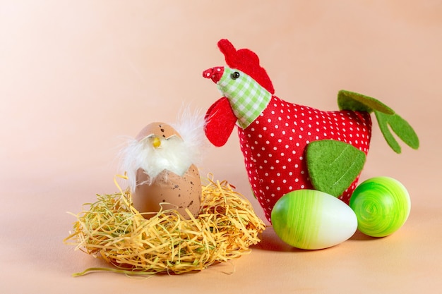 Zusammensetzung von Ostereiern, Textilhuhn und Huhn im Nest