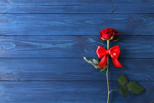 Zusammensetzung von roten Rosen auf blauem Hintergrund aus Holz, Valentinstag. Platz für Text.