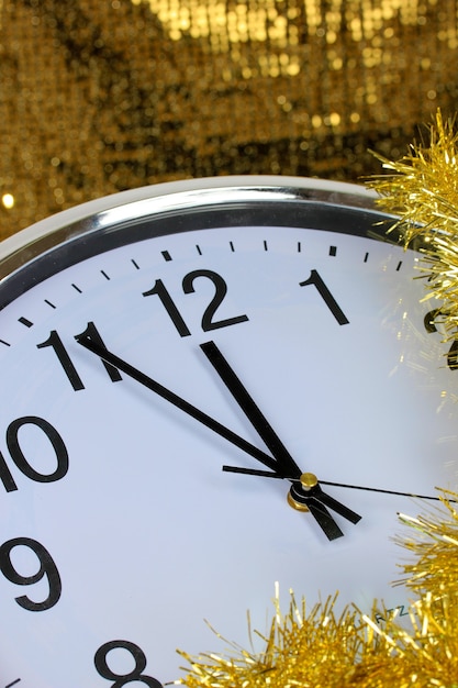 Zusammensetzung von Uhr und Weihnachtsschmuck auf hellem Hintergrund