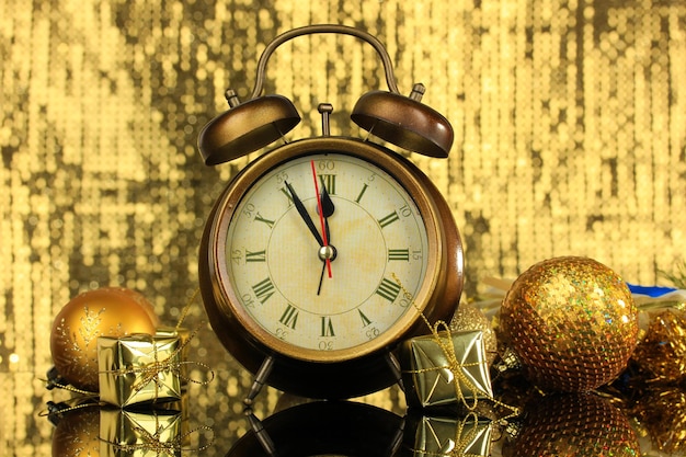 Zusammensetzung von Uhr und Weihnachtsschmuck auf hellem Hintergrund