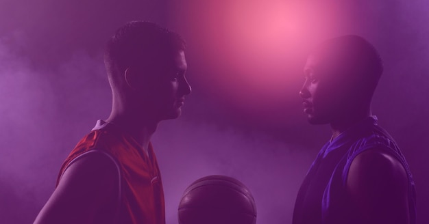 Zusammensetzung von zwei Basketballspielern, die Ball auf lila getöntem Hintergrund halten