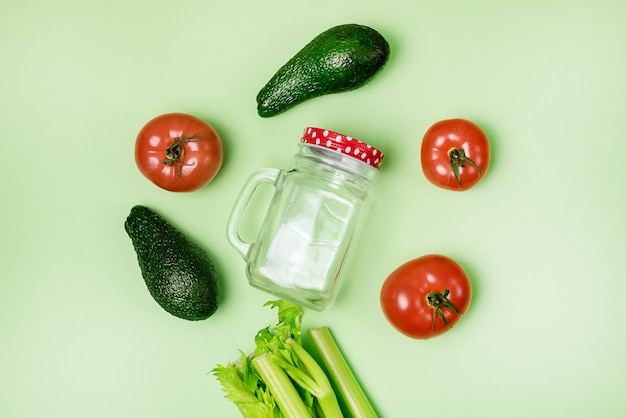 Zutat für gesunde Detox-Smoothie, grüne Sellerie-Avocado-Tomaten und Glas auf grünem Hintergrund