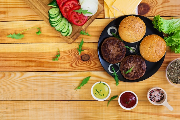 Zutaten für Burger auf Holz. Ansicht von oben