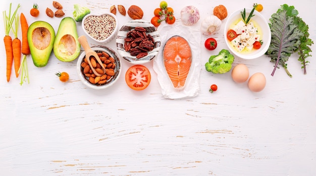 Zutaten für die Auswahl an gesunden Lebensmitteln auf weißem Holzhintergrund