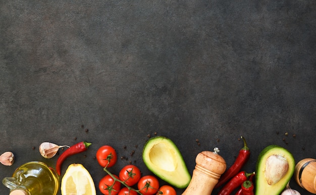 Zutaten für die Herstellung von Guacamole-Sauce. Essen auf einem schwarzen Tisch aus Beton mit Platz für Text.