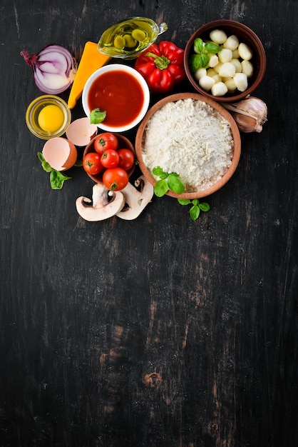 Zutaten für die Herstellung von Pizza Auf einem hölzernen Hintergrund Ansicht von oben Freier Platz für Ihren Text