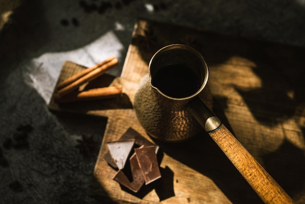 Zutaten für die Zubereitung von Kaffee-Zimt-Schokolade-Gewürzen auf einem braunen Holzbrett 4