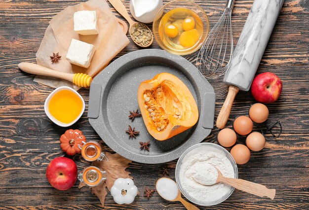 Zutaten für die Zubereitung von Kürbiskuchen auf Holztisch