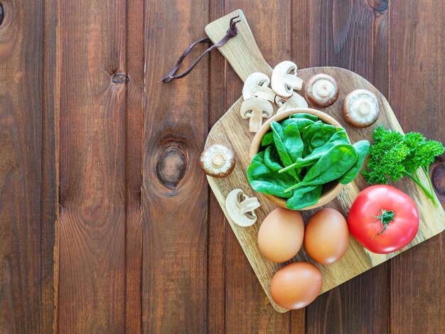 Zutaten für Eieromelette mit Spinat, Pilzen, Tomaten und Petersilie Das Konzept der gesunden Ernährung