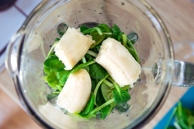 Zutaten für grüne Detox-Smoothies in einem Mixer. Spinat, Banane und Avocado. Seitenansicht