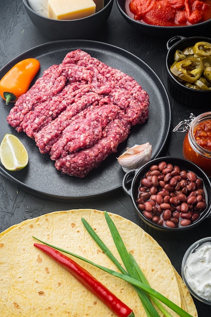 Zutaten für mexikanische Quesadilla mit Salsa-Sauce auf schwarzem Tisch