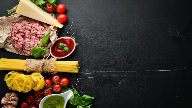 Zutaten für Pasta Bolognese Auf schwarzem Hintergrund Ansicht von oben Freier Platz für Ihren Text