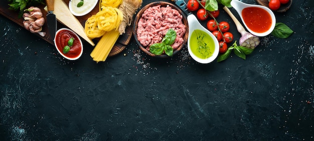 Zutaten für Pasta Bolognese Auf schwarzem Hintergrund Ansicht von oben Freier Platz für Ihren Text