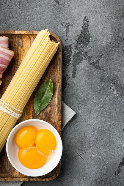 Zutaten für Pasta Carbonara Traditionelles italienisches Essen auf grauem Steinhintergrund Draufsicht flach mit Kopierplatz für Text